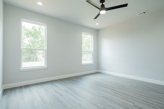 empty room featuring light wood-type flooring, baseboards, visible vents, and recessed lighting