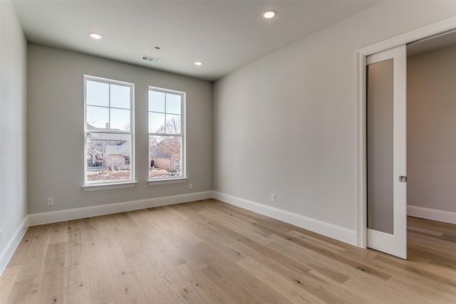 spare room featuring light wood-type flooring, visible vents, baseboards, and recessed lighting