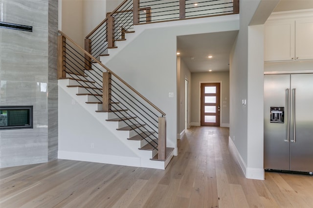 entryway with light wood-type flooring, stairway, baseboards, and recessed lighting