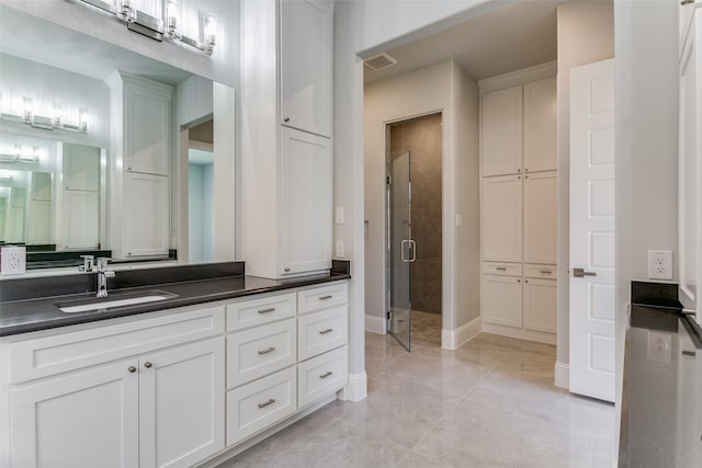 bathroom with a shower stall, visible vents, baseboards, and vanity