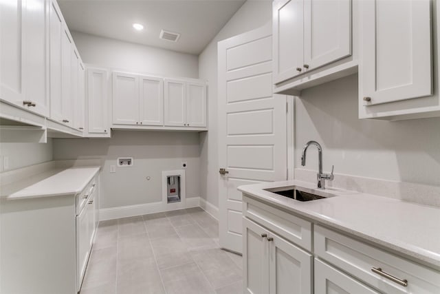 clothes washing area with hookup for a washing machine, a sink, visible vents, cabinet space, and electric dryer hookup