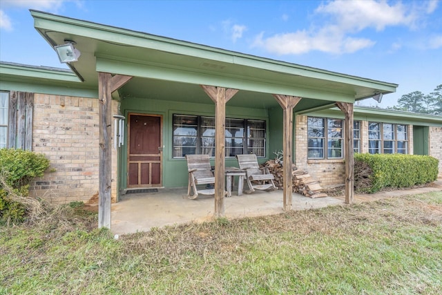 entrance to property with a yard and brick siding