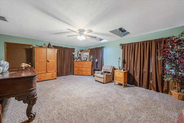 sitting room featuring a ceiling fan, visible vents, carpet floors, and a textured ceiling