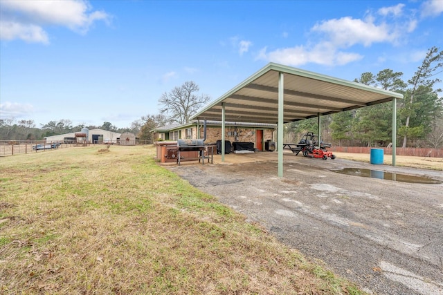 view of parking with a carport and fence