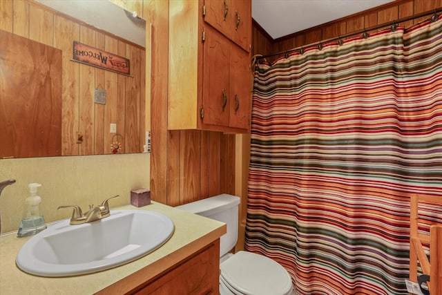 full bathroom with wood walls, vanity, and toilet