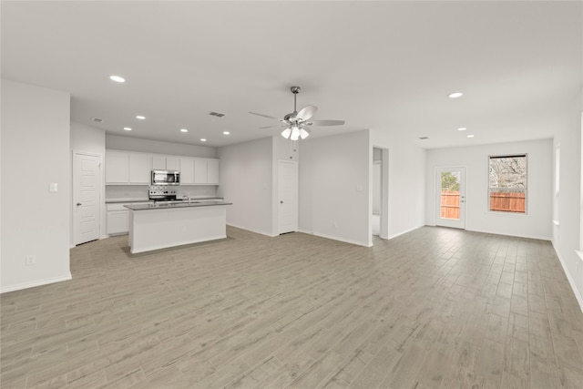 unfurnished living room with recessed lighting, baseboards, light wood-style flooring, and a ceiling fan