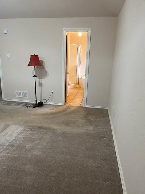 carpeted empty room featuring visible vents and baseboards