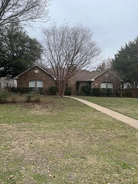 view of front of property featuring brick siding and a front lawn