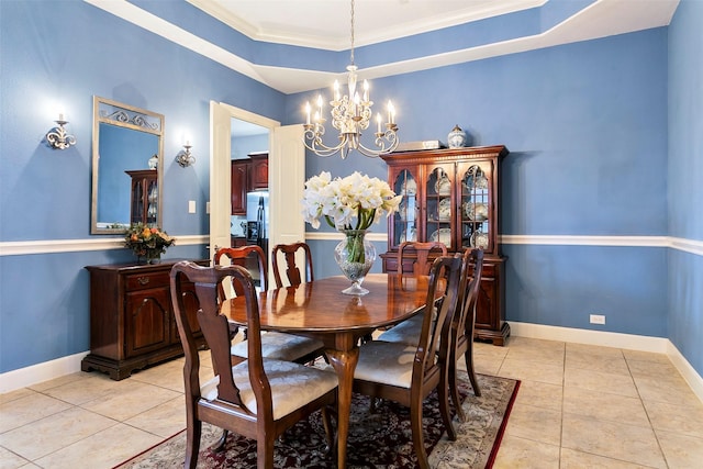 dining area featuring light tile patterned floors, a tray ceiling, baseboards, and an inviting chandelier