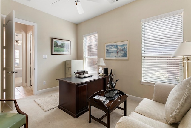 home office featuring visible vents, baseboards, light colored carpet, and ceiling fan