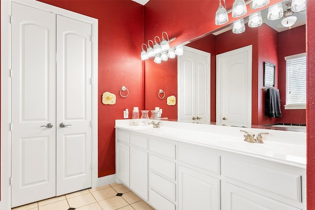 bathroom with double vanity, a closet, tile patterned floors, and a sink