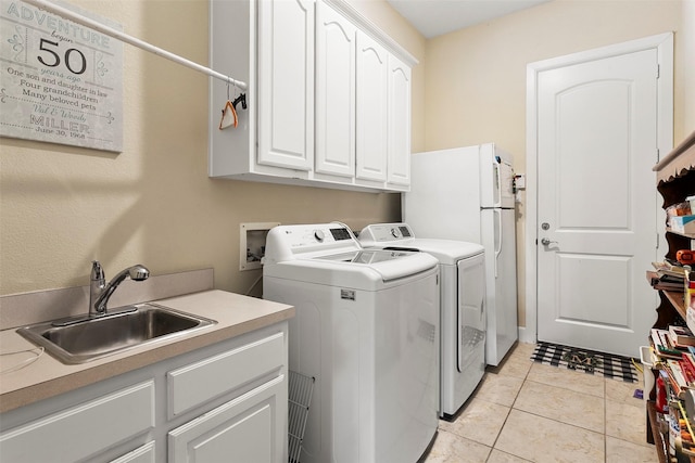 laundry room featuring light tile patterned flooring, cabinet space, independent washer and dryer, and a sink