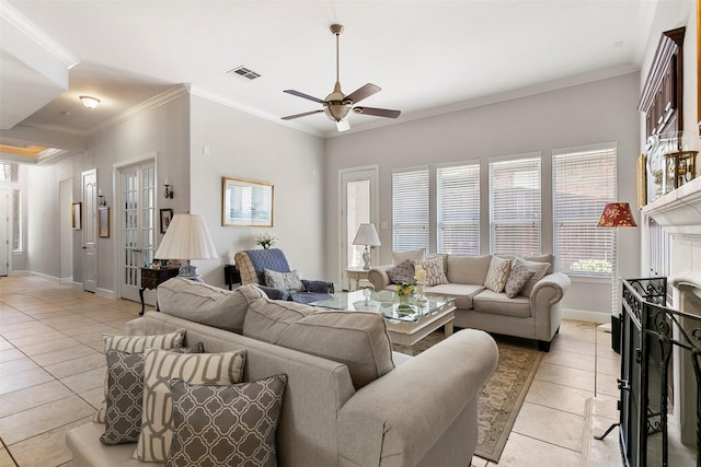 living room with light tile patterned floors, a ceiling fan, visible vents, baseboards, and crown molding