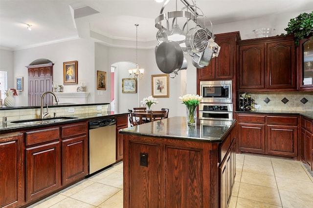 kitchen featuring a sink, stainless steel appliances, dark brown cabinets, backsplash, and a chandelier