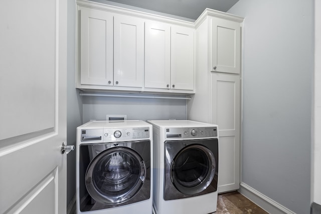 clothes washing area with cabinet space, baseboards, and washing machine and clothes dryer