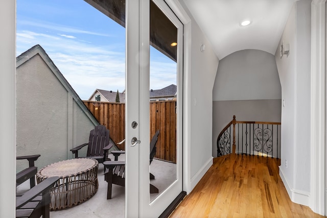 interior space with light wood finished floors, an upstairs landing, and baseboards