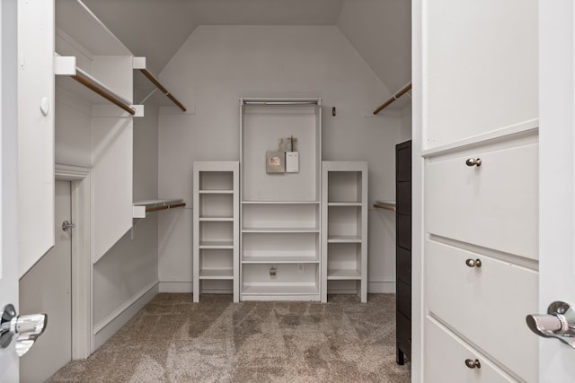 spacious closet featuring vaulted ceiling and light colored carpet