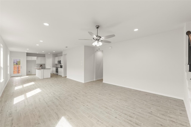 unfurnished living room featuring recessed lighting, baseboards, light wood-type flooring, and a ceiling fan