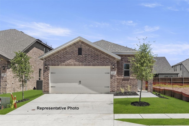 view of front of property with brick siding, an attached garage, fence, driveway, and a front lawn