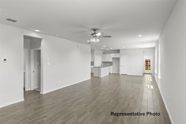 unfurnished living room with visible vents, baseboards, dark wood-style floors, ceiling fan, and recessed lighting