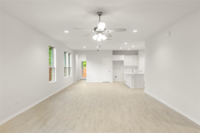 1810 Iris Rd, Melissa, TX 75454 - unfurnished living room featuring a ceiling fan, baseboards, light wood finished floors, recessed lighting, and a sink
