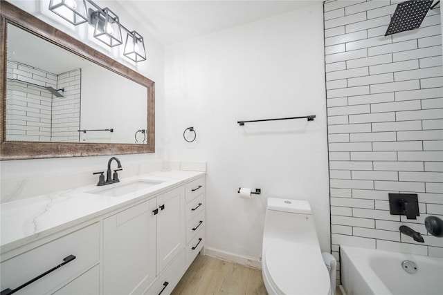 full bathroom featuring toilet, wood finished floors, vanity, baseboards, and shower / bathing tub combination