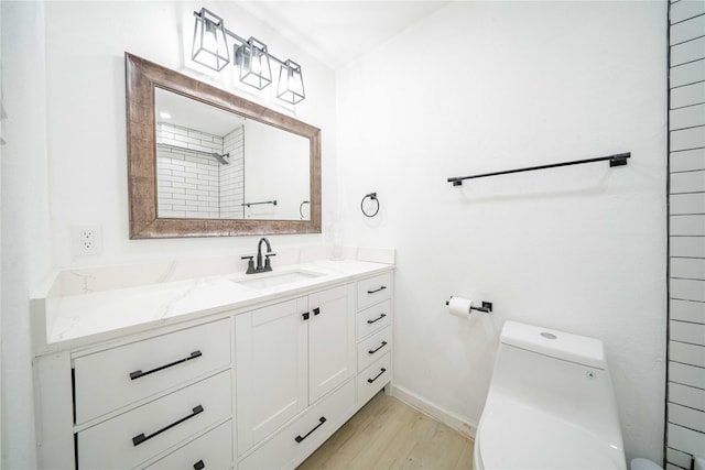 full bathroom featuring toilet, baseboards, wood finished floors, and vanity