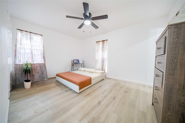 unfurnished bedroom featuring light wood finished floors, ceiling fan, and baseboards