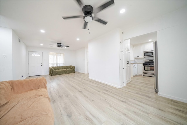 unfurnished living room featuring recessed lighting, light wood-style flooring, and baseboards