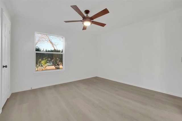 spare room featuring baseboards, ceiling fan, and light wood-style floors