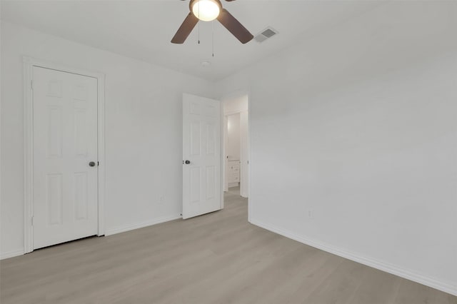 unfurnished bedroom with a ceiling fan, light wood-style flooring, visible vents, and baseboards