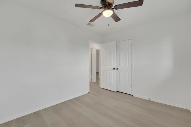 unfurnished bedroom with light wood-style floors, visible vents, baseboards, and a closet