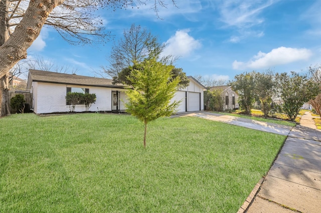 view of front of property featuring a garage, a front yard, brick siding, and driveway