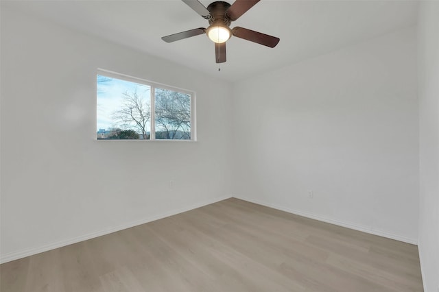 unfurnished room with ceiling fan, light wood-style flooring, and baseboards