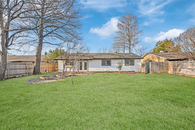 back of house with a yard, french doors, and a fenced backyard