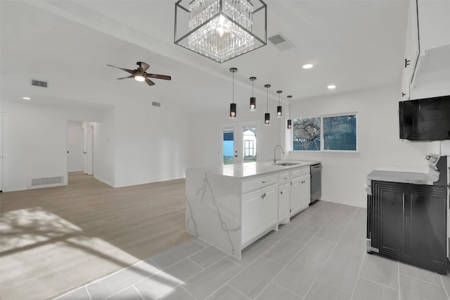 kitchen featuring pendant lighting, stainless steel dishwasher, visible vents, and white cabinets