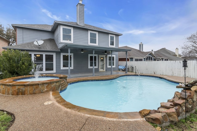 view of swimming pool featuring a patio area, fence, a ceiling fan, and a pool with connected hot tub