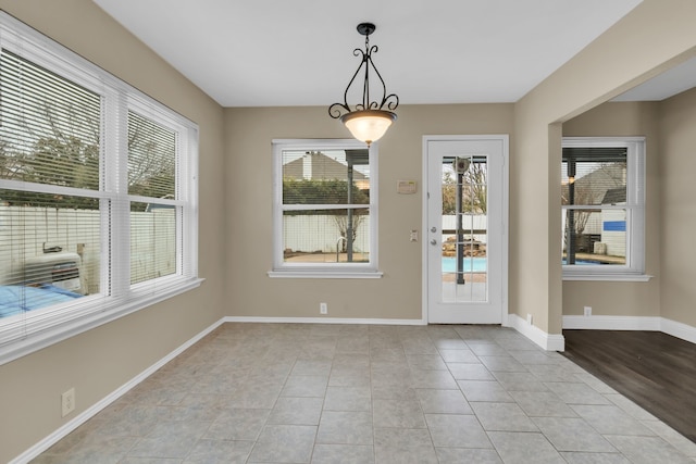 doorway featuring baseboards and light tile patterned flooring