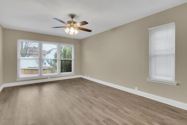spare room featuring baseboards, a ceiling fan, and wood finished floors