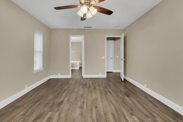 unfurnished bedroom featuring baseboards, a ceiling fan, visible vents, and dark wood-style floors