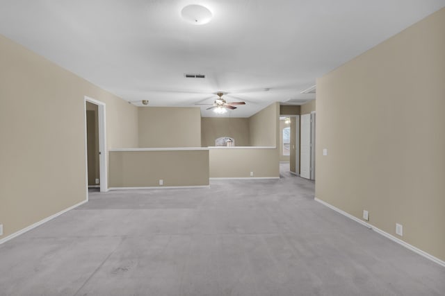 empty room featuring ceiling fan, baseboards, visible vents, and light carpet