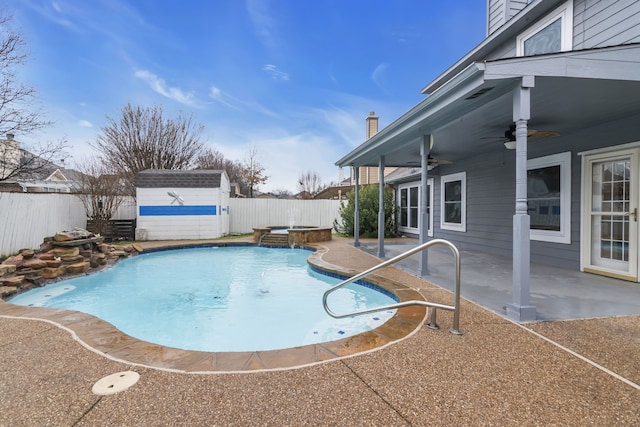 view of swimming pool with a ceiling fan, a patio area, a shed, and a fenced backyard