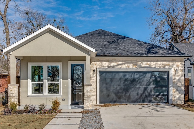 view of front facade featuring a garage, a shingled roof, concrete driveway, stone siding, and stucco siding