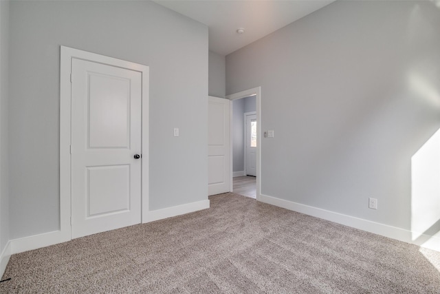 unfurnished bedroom with light carpet and baseboards