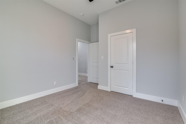 unfurnished bedroom with carpet floors, visible vents, and baseboards