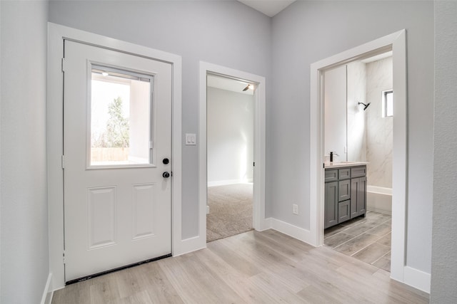 foyer with light wood finished floors and baseboards