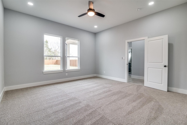 empty room featuring light carpet, ceiling fan, baseboards, and recessed lighting