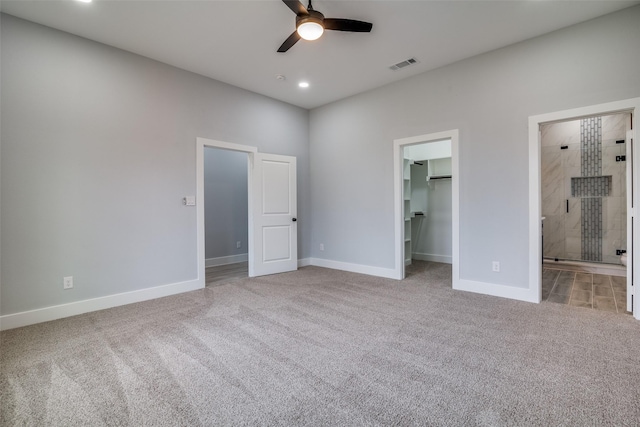 unfurnished bedroom featuring baseboards, visible vents, light colored carpet, a walk in closet, and recessed lighting