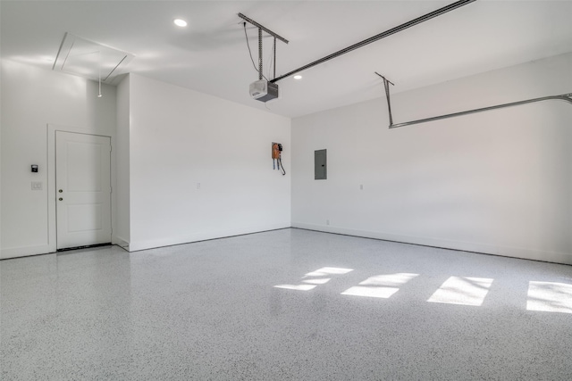 garage featuring baseboards, electric panel, and a garage door opener