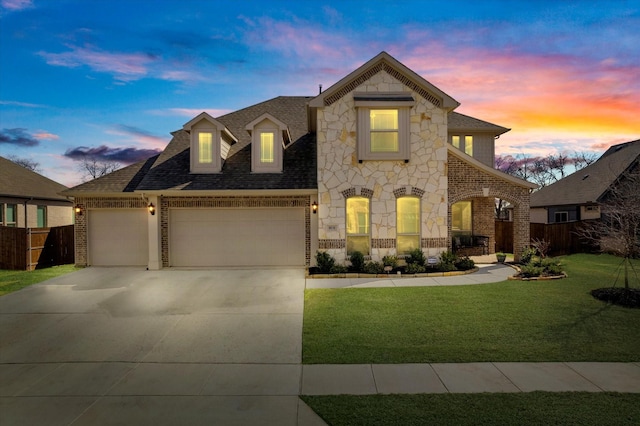 view of front facade featuring an attached garage, brick siding, concrete driveway, stone siding, and a front yard